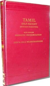 Red hardcover book titled 'Tamil Self-Taught on Roman Characters' with gold lettering, noting English phonetic pronunciation; by Don N. de Z. Wickremasinghe, standing upright.